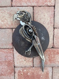 a bird made of metal on a brick wall
