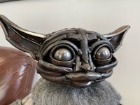 a metal yoda mask on a chair