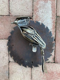 a bird is sitting on top of a metal plate