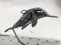 a metal dolphin sculpture on top of a metal shelf