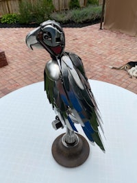 a bird made out of metal spoons on a table